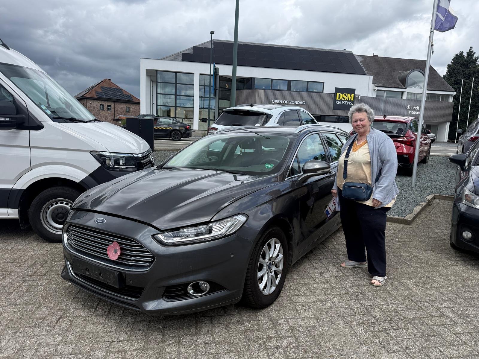Ford opkoper Vrouw naast een grijze Ford Mondeo in Tervuren