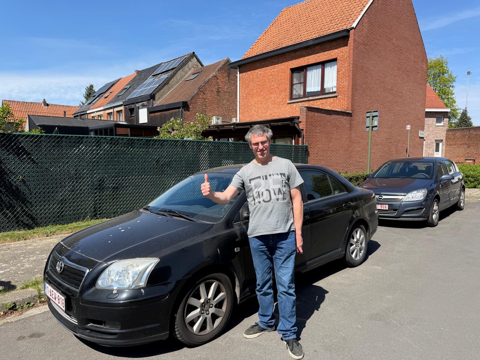 Eigenaar naast zijn Toyota Avensis uit 2006 bij de verkoop aan CarSwitch in Sint-Truiden