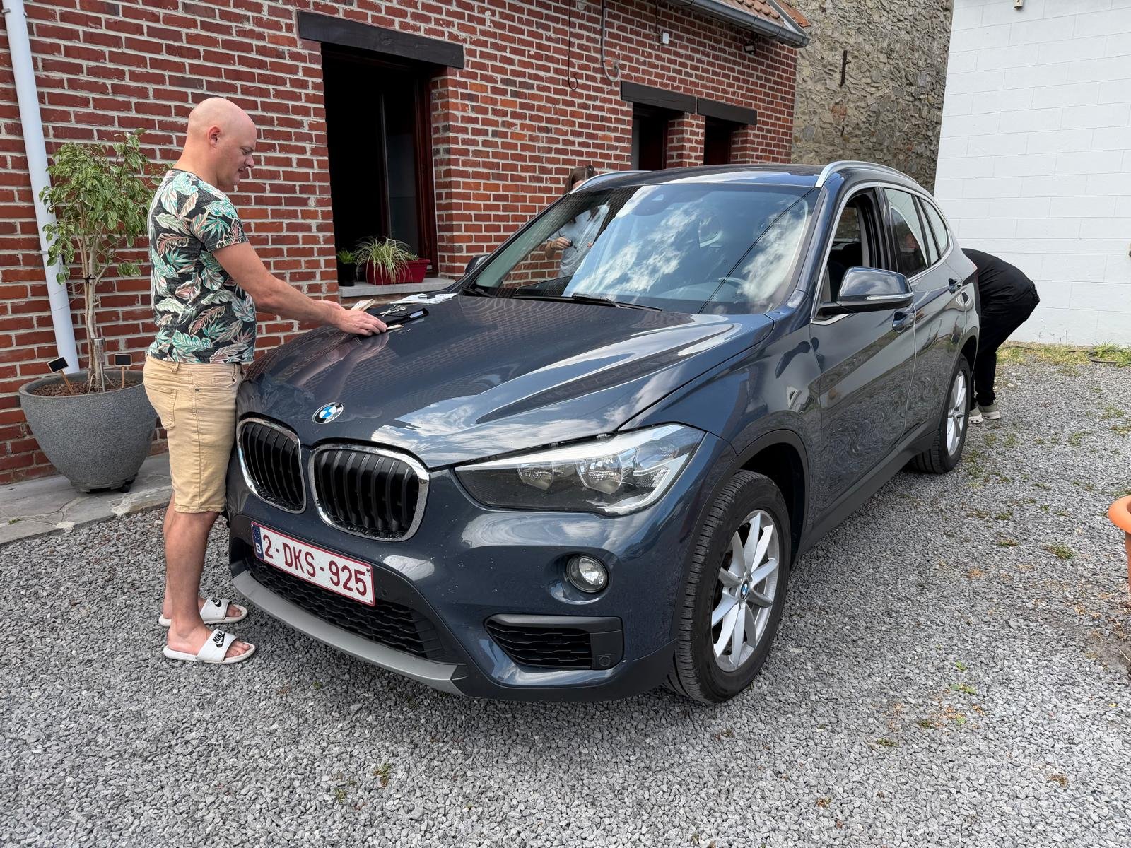 Grijze BMW X1 uit 2016 bij een woning in Zandhoven
