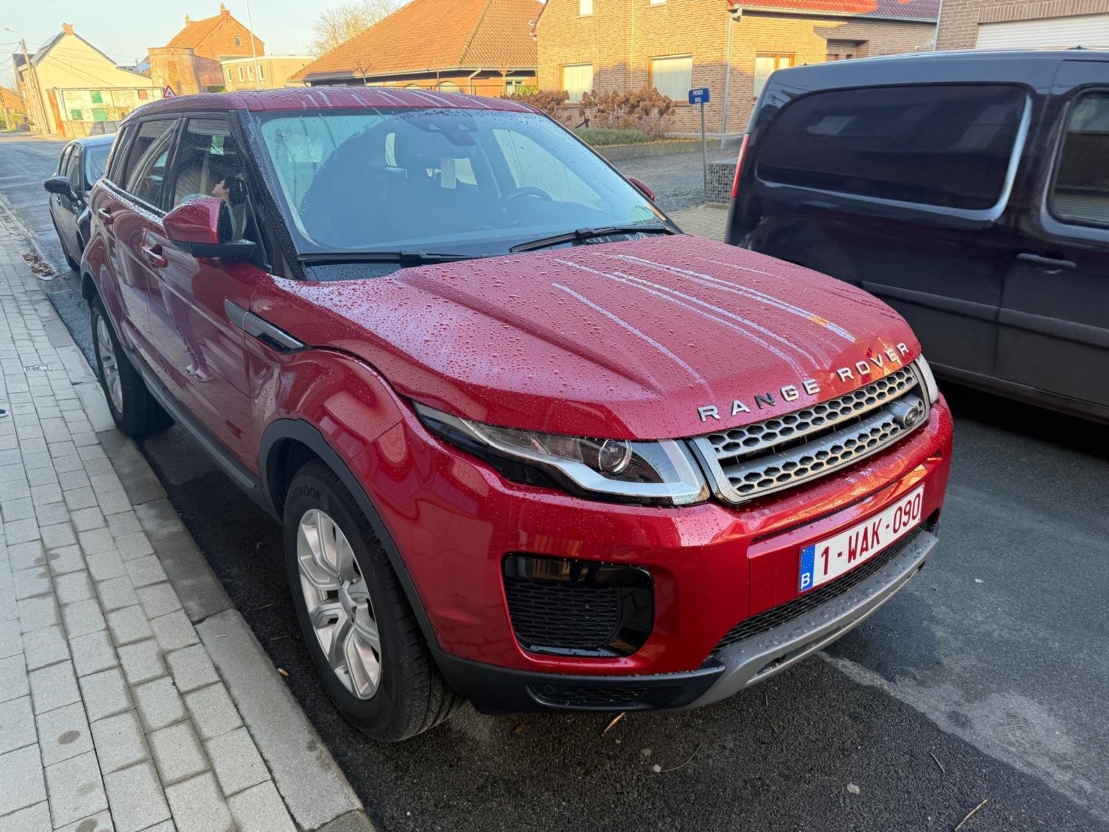 Rode Range Rover Evoque uit 2017 geparkeerd langs een straat